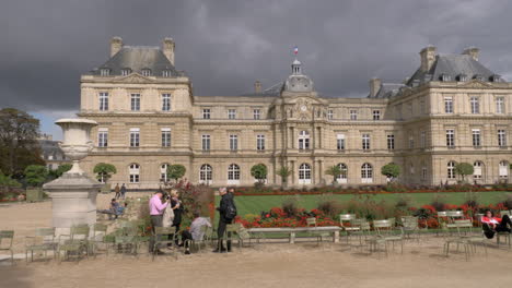 Palacio-En-Los-Jardines-De-Luxemburgo-Con-Visitantes-Relajándose-Al-Aire-Libre-En-París