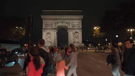 Vista-De-La-Ciudad-Con-Arco-De-Triunfo-En-La-Noche-Paris-Gente-Cruzando-La-Calle