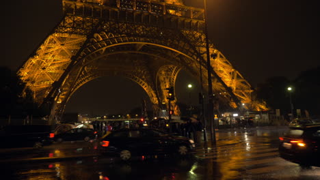 Calle-De-París-En-Una-Noche-Lluviosa,-Autos-Conduciendo-Y-Gente-Cruzando-La-Calle.