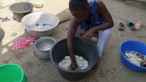Preparación-De-Comida-Tradicional-De-Ghana-Llamada-Fufu,-Primer-Plano-De-Una-Mujer-Africana-Negra-Limpiando-Con-Verduras-De-Agua-Dulce