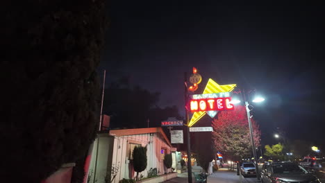 Walking-along-the-sidewalk-to-reveal-the-Sant-Fe-Motel-at-nighttime