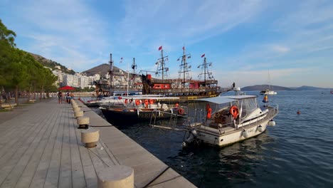 Pirate-Adventures-Await:-Tour-Ships-with-Playful-Pirate-Decorations-Anchor-in-Saranda's-Coastal-Bay,-A-Unique-Maritime-Experience-for-Tourists