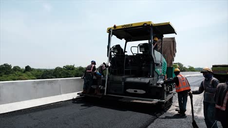 Compressing,-compacting,-leveling-and-smoothing-the-asphalt-road-surface-using-a-Asphalt-Paver-Finisher