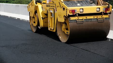 Compressing,-compacting,-leveling-and-smoothing-the-asphalt-road-surface-using-a-tandem-roller