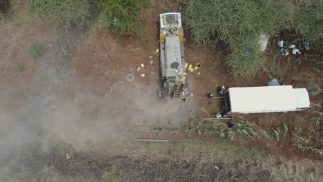 Top-down-aerial-view-on-boring-machine-drilling-water-well-in-Africa-dry-soil