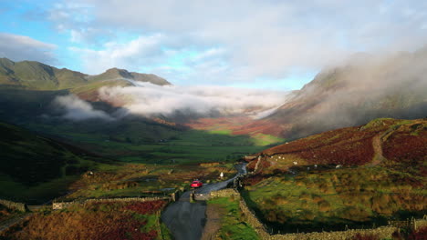 Mountain-pass-on-early-autumn-morning-with-flight-backwards-revealing-parked-car-and-hiker