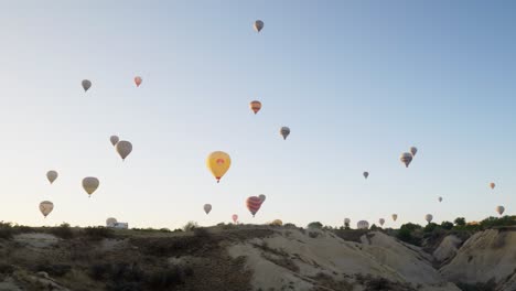 Hot-air-balloons-fly-over-rugged-landscape-scenery-Tourist-destination