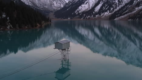 Aerial-view-around-a-watchtower-in-middle-of-the-Big-Almaty-Lake-in-snowy-Kazakhstan