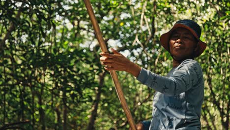 Old-Balinese-woman-rowing-a-boat-through-the-greenery-of-a-mangrove-on-the-island-of-Nusa-Lembongan