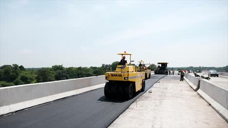 Compressing,-compacting,-leveling-and-smoothing-the-asphalt-road-surface-using-a-Tyre-Roller,-tandem-roller-and-Asphalt-Paver-Finisher