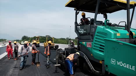 Comprimir,-Compactar,-Nivelar-Y-Alisar-La-Superficie-De-La-Carretera-Asfáltica-Utilizando-Un-Rodillo-Para-Neumáticos,-Un-Rodillo-Tándem-Y-Una-Terminadora-De-Asfalto