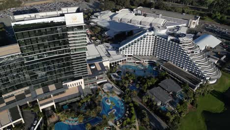 Toma-Aérea-De-Arriba-Hacia-Abajo-Del-Moderno-Hotel-Casino-Crown-De-Lujo-En-La-Ciudad-De-Perth-Al-Atardecer---Apartamento-Con-Piscina-En-El-Oeste-De-Australia