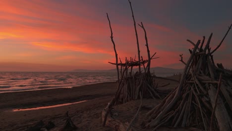 Sandy-beach-with-driftwood-tipis-during-sunset