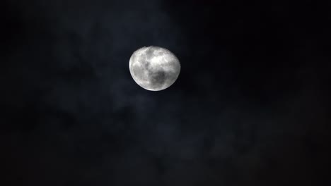 Helle-Weiße-Mondkrater-Und--kämme-Ragen-In-Den-Himmel,-Während-Nachts-Wolken-Darunter-Vorbeiziehen