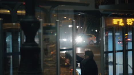 Street-in-night-city-with-traffic-and-bus-stop-Madrid-Spain