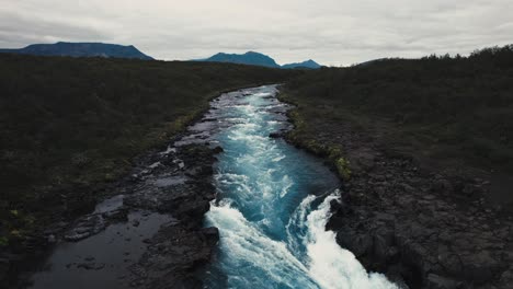Aerial-clear-blue-waterfall-river-hlauptungufoss-Iceland,-beautiful-moody-icelandic-landscape