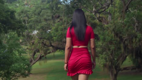 The-Caribbean's-tropical-allure-was-heightened-by-a-woman-in-a-stunning-red-dress-at-a-park-on-a-sunny-day