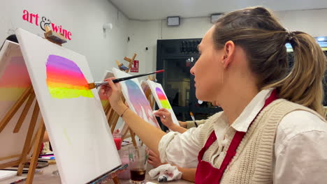 Mujer-Creativa-Joven-Caucásica-Pintando-Un-Lienzo-En-Un-Estudio-De-Arte-Y-Vino.