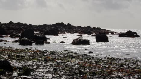 silhouette-shot-of-exposed-rocks-at-low-tide