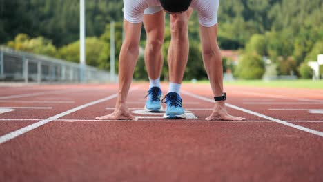 Sportlicher-Läufer-Geht-Auf-Der-Laufstrecke-In-Die-Startposition