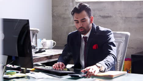 Young-Hispanic-businessman-using-computer-in-his-office