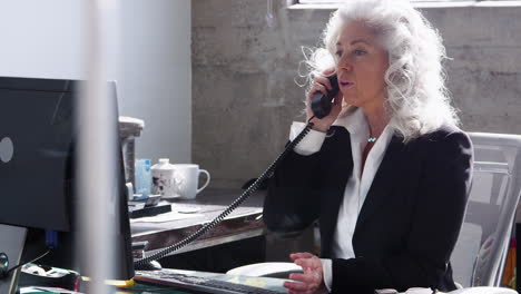 Empresaria-Blanca-Senior-Hablando-Por-Teléfono-En-Su-Oficina