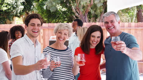 Parents-and-adult-children-raise-glasses-to-camera-in-garden