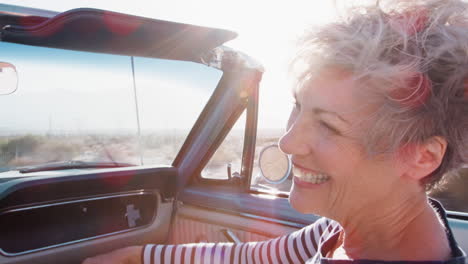 Happy-senior-female-passenger-in-a-convertible-car,-close-up