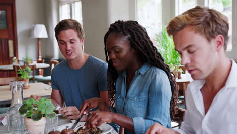 Group-Of-Young-Friends-Enjoying-Meal-In-Restaurant-Together