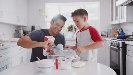 Jump-Cut-Clip-Von-Vater-Und-Sohn-Im-Teenageralter,-Die-In-Ihrer-Küche-Kuchenmischung-Zubereiten-Und-Kuchen-Backen