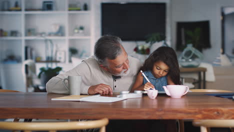 Senior-Hispanic-man-sitting-with-his-granddaughter,-who-uses-stylus-and-tablet-computer,-close-up