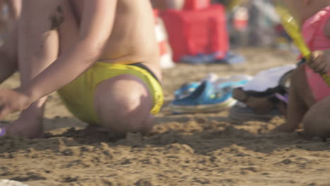 Niño-Y-Hermana-Menor-Jugando-Con-Arena-En-La-Playa