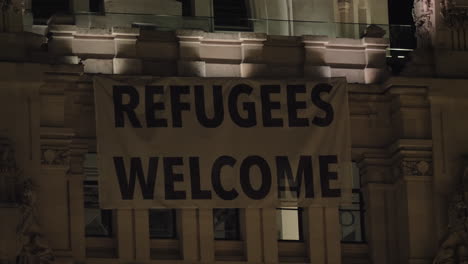 Night-view-of-Refugee-Welcome-banner-on-Cybele-Palace-in-Madrid