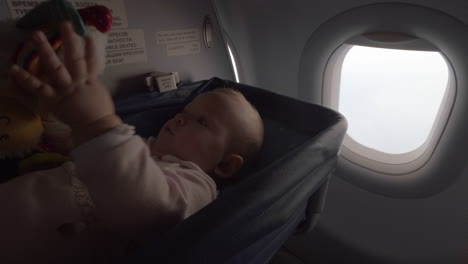 Kleines-Mädchen-In-Einer-Wiege-In-Einem-Flugzeug