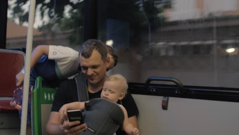 Dad-with-two-children-on-the-bus