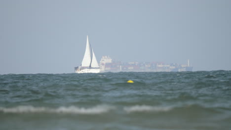 Sailboat-and-cargo-ship-in-the-sea