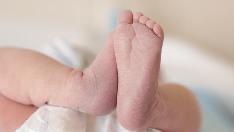 Newborn-baby-girl-with-her-feet-in-the-air