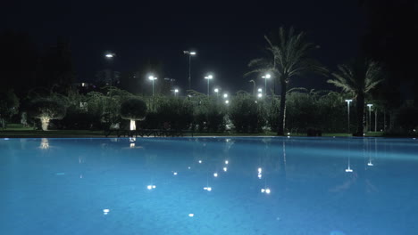 Eine-Steadicam-Aufnahme-Einer-Glänzenden,-Offenen-Pooloberfläche-Bei-Nachtbeleuchtung