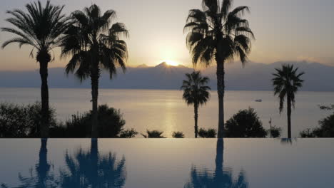 Escena-Del-Resort-En-La-Piscina-Al-Atardecer-Con-Vistas-Al-Mar.