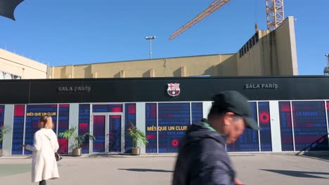 Visitors-walk-past-the-construction-work-site-that-has-begun-on-the-new-Spotify-Camp-Nou,-Barcelona-football-club-stadium