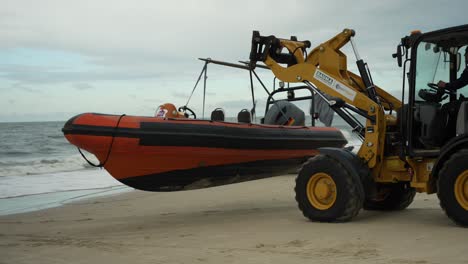Forklift-carrying-boat-on-sandy-beach,-water-sports-event-crew