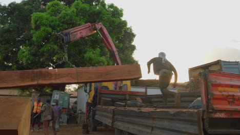 Schwarze-Arbeiter-Der-Arbeiterklasse-In-Einer-Sägewerksfabrik-In-Afrika,-Die-Geschnittene-Baumstämme-Aus-Holz-Nach-Übersee-Exportieren