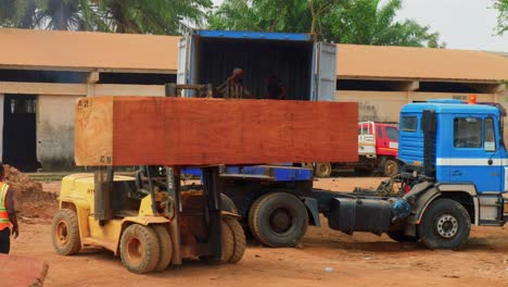sawmill-factory-black-male-working-class-labor-loading-a-truck-with-wooden-trunk-cut-tree
