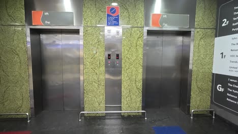 Toma-En-Primera-Persona,-Hombres-Bajando-Del-Ascensor-Dentro-Del-Centro-Comercial-Y-Dirigiéndose-Al-Estacionamiento.