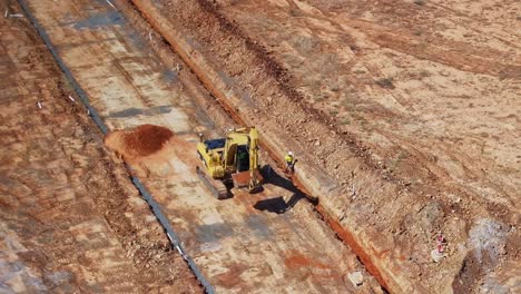 Yarrawonga,-Victoria,-Australia---22-November-2023:-Worker-and-a-track-loader-working-together-to-fill-a-trench-with-soil-on-a-building-site-at-Silverwoods-Estate-Yarrawonga