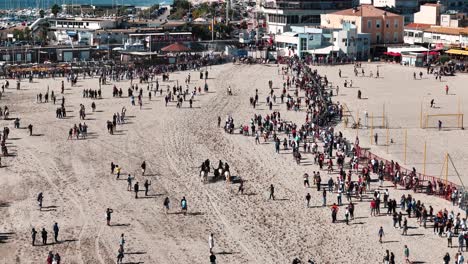 Aerial-shot:-Event-on-the-public-beach-of-Palavas,-France-with-horses-and-bulls-entertainment-surrounded-by-crowd-of-people