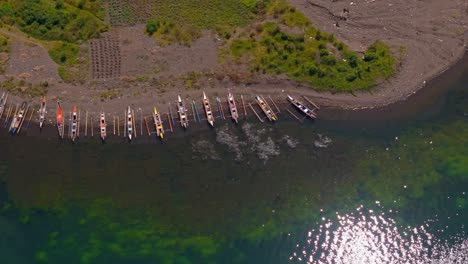 Larga-Fila-De-Kayaks-De-Pesca-Atracados-A-Lo-Largo-De-La-Costa-Del-Lago-Mainit