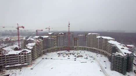 An-aerial-view-of-a-multi-storey-building-construction-in-the-snow