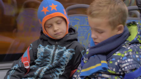 Children-watching-cartoon-on-mobile-during-bus-ride