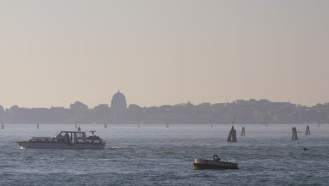 Una-Lancha-Motora-Cruzando-El-Agua-Frente-A-La-Hermosa-Vista-Nocturna-De-Venecia.